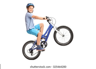 Joyful little boy performing a wheelie with his bike and looking at the camera isolated on white background - Powered by Shutterstock