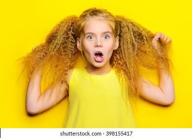 Joyful Little Girl With Beautiful Blonde Hair Over Yellow Background. Kid's Style. Hairstyle.