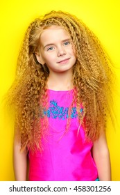 Joyful Little Girl With Beautiful Blonde Hair Over Yellow Background. Kid's Style. Hairstyle.