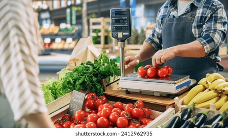 Joyful Local Farmer Running a Small Business, Selling Sustainable Farm Fruits and Vegetables. Bearded Middle Aged Male Welcoming a Female Shopper to Buy a Vine of Tomatoes From an Organic Farm - Powered by Shutterstock