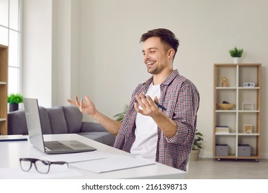 Joyful male freelancer or student working on laptop has finally found information he needs on Internet. Smiling guy sits at table in living room or office and uses laptop to find idea or good solution - Shutterstock ID 2161398713