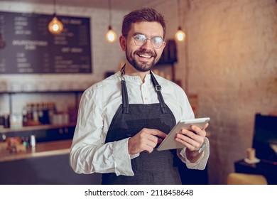 Joyful male worker using tablet computer in cafe - Powered by Shutterstock