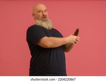 A joyful man with a gray beard holds a bump in his hands on a colored background. The concept of male potency - Shutterstock ID 2204220867