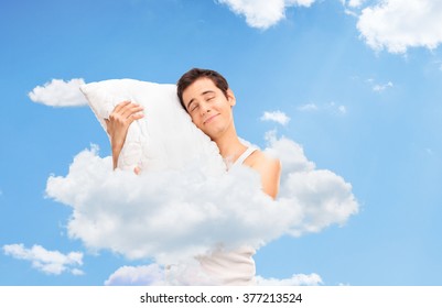 Joyful Man Sleeping And Hugging A Soft Pillow Up In Clouds In The Sky