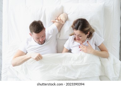 Joyful Man And Woman Looking Under Blanket While Lying In Bed