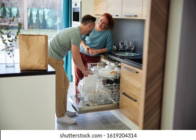 Joyful Man And Woman Are Using Dishwasher Together At Home