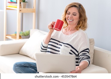 Joyful Mature Lady Watching Movie On Computer