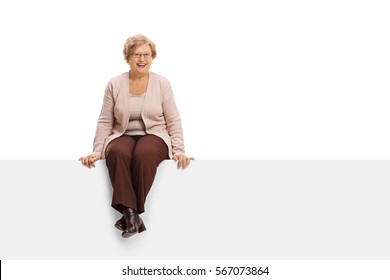 Joyful mature woman sitting on a panel isolated on white background
