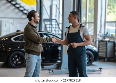 Joyful Mechanic Greeting His Customer At The Service Station