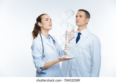 Joyful Medical Colleagues Looking At Plastic Dna Model Together