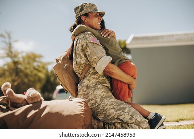 Joyful Military Mom Embracing Her Son After Returning Home From The Army. Courageous Female Soldier Reuniting With Her Young Child After Serving In The Military.