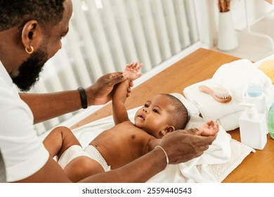 A joyful moment between a father and his baby during a playful interaction on a changing table. Happy diversity family and newborn bathing concept. - Powered by Shutterstock