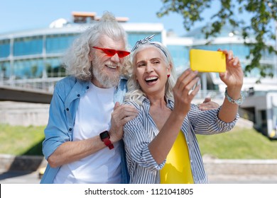 Joyful mood. Cheerful positive woman taking a selfie while being together with her husband
