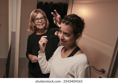 Joyful mother and daughter bonding over morning makeup routine. Mother's Day - Powered by Shutterstock