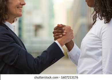 Joyful Multiethnic Colleagues Celebrating Team Success. Closeup Of Business Women Giving Friendly Handshake Outside. Communication Or Leadership Concept