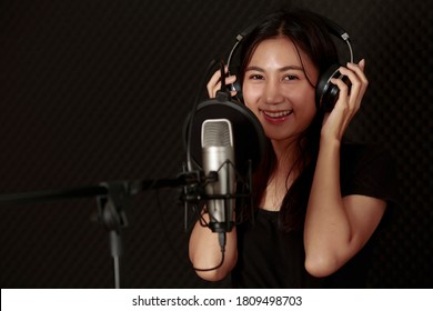 Joyful Optimistic Glad Young Female Singer With Microphone And Headphone For Audio Recording In The Private Studio. Music, Show Business, People Singer And Voice Concept. Bangkok Thailand Asia