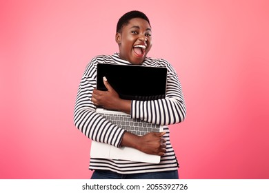 Joyful Overweight African American Lady Hugging Laptop Computer With Empty Screen Posing Over Pink Background. Website Advertisement And Online Technology Concept. Mockup, Studio Shot