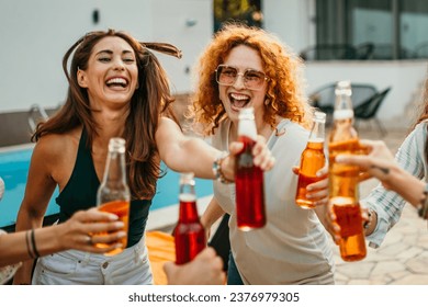 Joyful pals partying in the backyard, dancing and enjoying drinks by the pool - Powered by Shutterstock