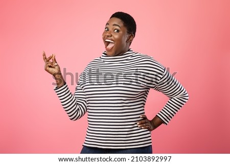 Joyful Plus-Sized African American Female Snapping Fingers Smiling Looking At Camera Standing Over Pink Studio Background. Excited Woman Gesturing Clicking Fingers. It's Easy Concept