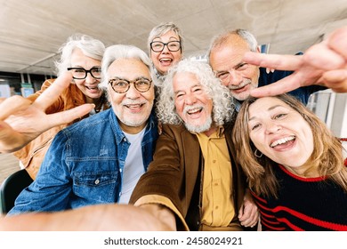 Joyful portrait of senior group of retired people enjoying time together taking selfie photo with phone. Elderly community people having fun during vacation. - Powered by Shutterstock