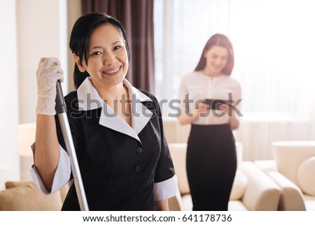 Joyful positive hotel maid smiling