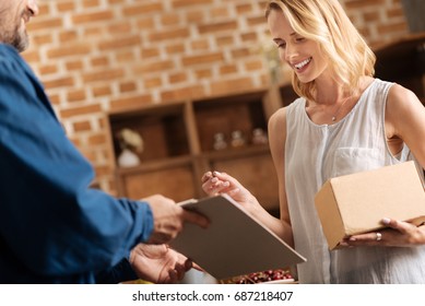Joyful pretty woman receiving a parcel