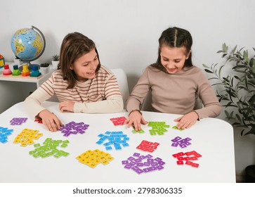 Joyful pupils constructing words using educational card tiles during lesson. Creative primary school learning concept for vocabulary expansion and cognitive skills training.