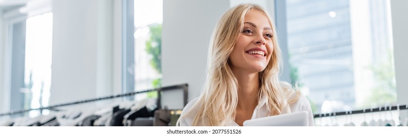 Joyful Sales Assistant In White Shirt Holding Digital Tablet In Clothing Boutique, Banner