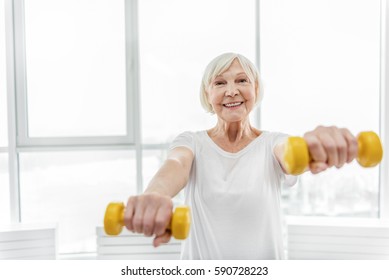 Joyful Senior Lady Exercising With Weights