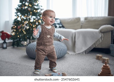 Joyful toddler exploring a cozy living room decorated for the holiday season - Powered by Shutterstock