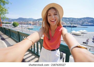 Joyful traveler girl takes self portrait in Nice old port, France - Powered by Shutterstock
