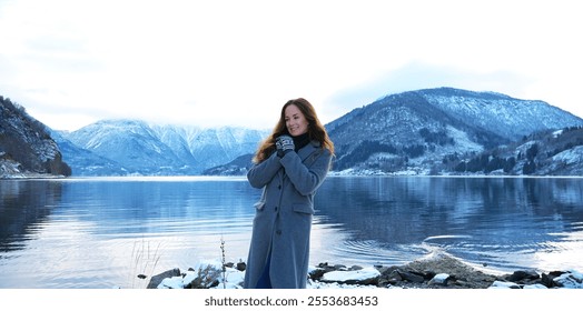 Joyful woman admiring snowy mountains and fjord in Gaupne, Norway winter - Powered by Shutterstock