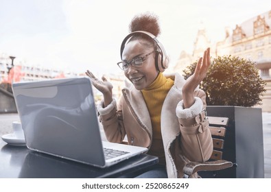 Joyful Woman Enjoying Virtual Meeting Outdoors in Vibrant City During Daylight Hours - Powered by Shutterstock