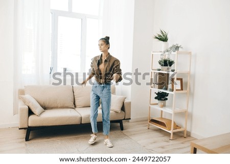 Joyful Woman Jumping for Happiness in Home Interior with Music and Fun