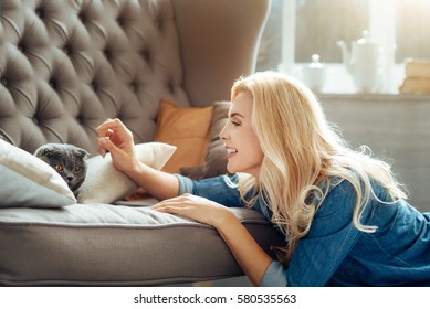 Joyful woman petting her cat