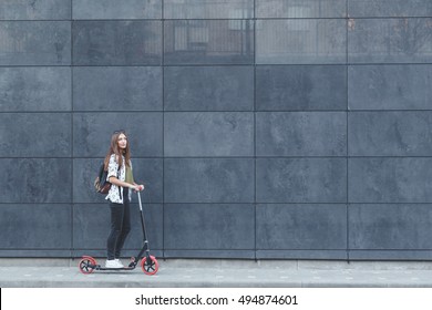 Joyful Woman Riding A Kick Scooter