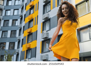 Joyful woman twirls in yellow dress - Powered by Shutterstock