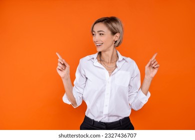 Joyful woman wearing white official style shirt pointing both sides to copy space