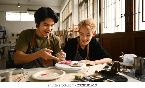 Joyful young asian gay couple creating handmade ceramics in art class. LGBTQ, indoors lifestyle activity concept - Powered by Shutterstock