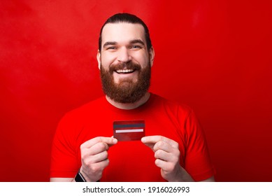 Joyful Young Bearded Hipster Man Holding Red Credit Card, My New Debit Card.