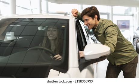 Joyful Young Caucasian Couple Checking New Luxury Car Before Purchase At Dealership Automobile Salon, Banner Design. Millennial Spouses Buying Or Renting Modern Auto At Showroom Store