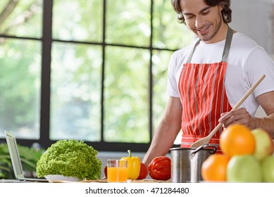 Joyful Young Guy Cooking At Home