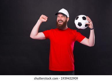 Joyful Young Man In Red T-shirt Holding Soccer Ball And Celebrate Victory.