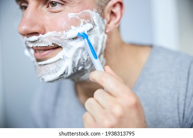 Joyful Young Man Saving Beard With Razor