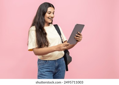 Joyful young student girl with backpack using digital tablet for online studying - Powered by Shutterstock