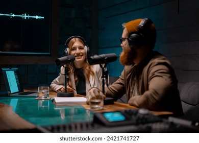 Joyful young stylish radio show hosts record fresh podcast episode in loft studio - Powered by Shutterstock