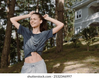 Joyful young woman enjoying a sunny day outdoors, playfully stretching her arms while smiling broadly Relaxation and happiness in nature concept - Powered by Shutterstock