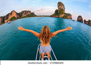 Joyful young woman portrait. Happy girl stand on deck of sailing yacht, have fun discovering islands in tropical sea on summer coastal cruise. Travel adventure, yachting with kids on family vacation.