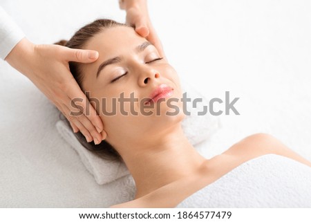 Similar – Young blond woman receiving a head massage