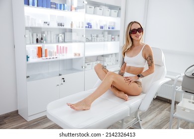 Joyful young woman sitting in daybed in beauty salon